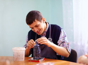 young adult man with disability engaged in craftsmanship